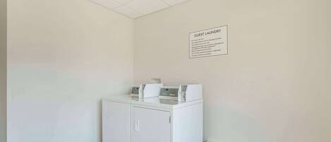 A guest laundry area with a sign detailing usage rules.
