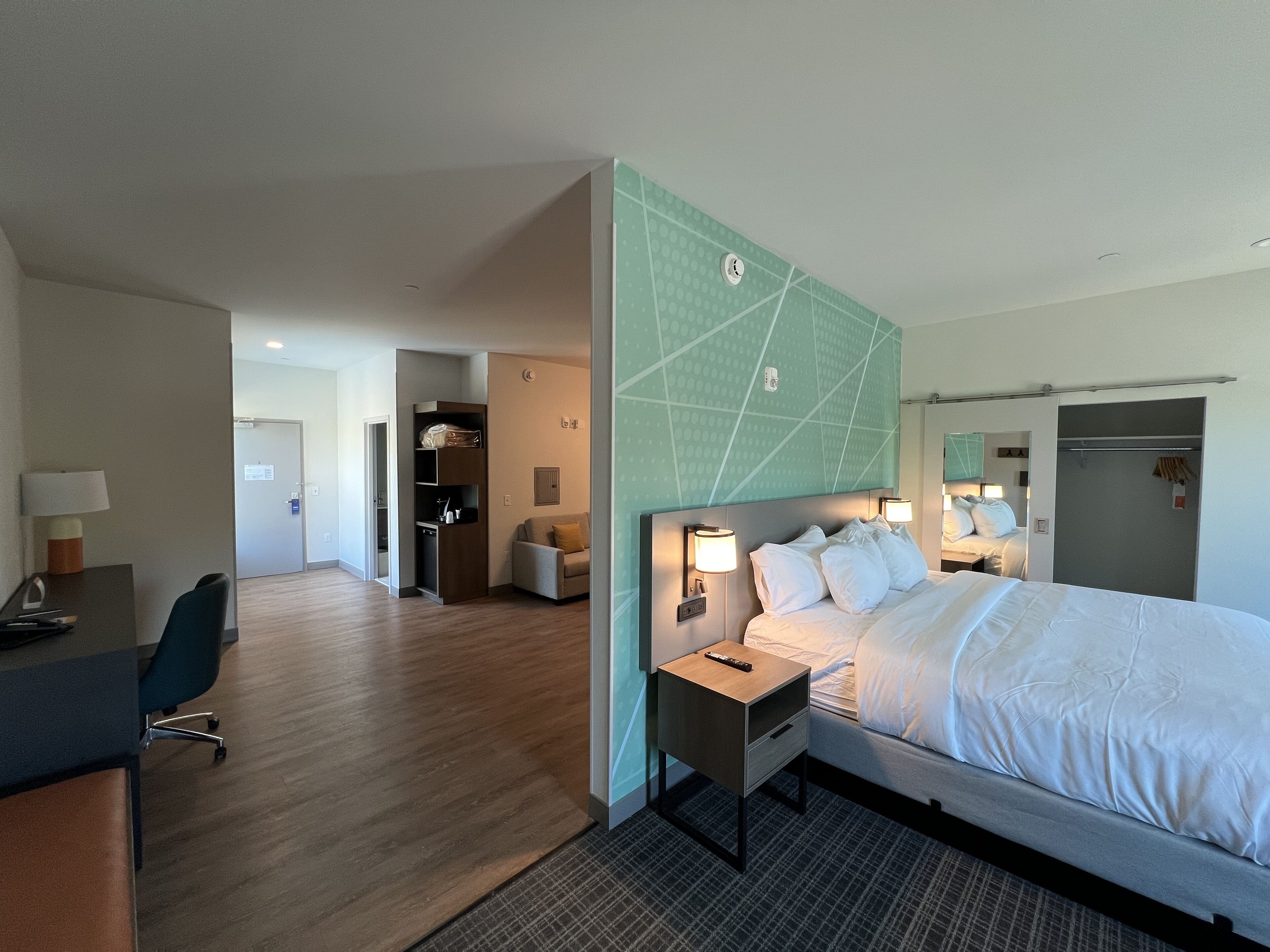 Une chambre d’hôtel comprenant un lit, des tables de chevet, un bureau et une chaise.