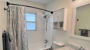 Un baño con ducha, inodoro y lavamanos.
