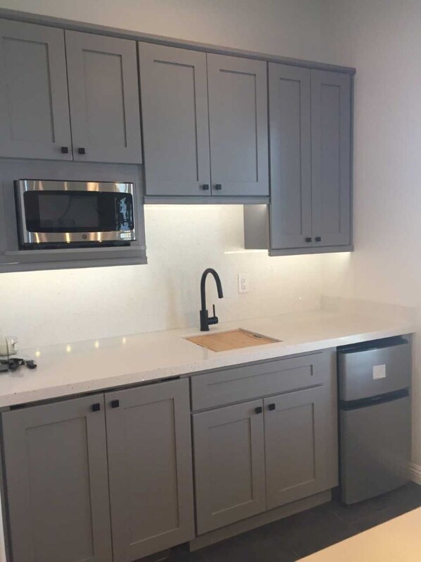 Modern kitchen with stainless steel microwave, black faucet, and dishwasher.