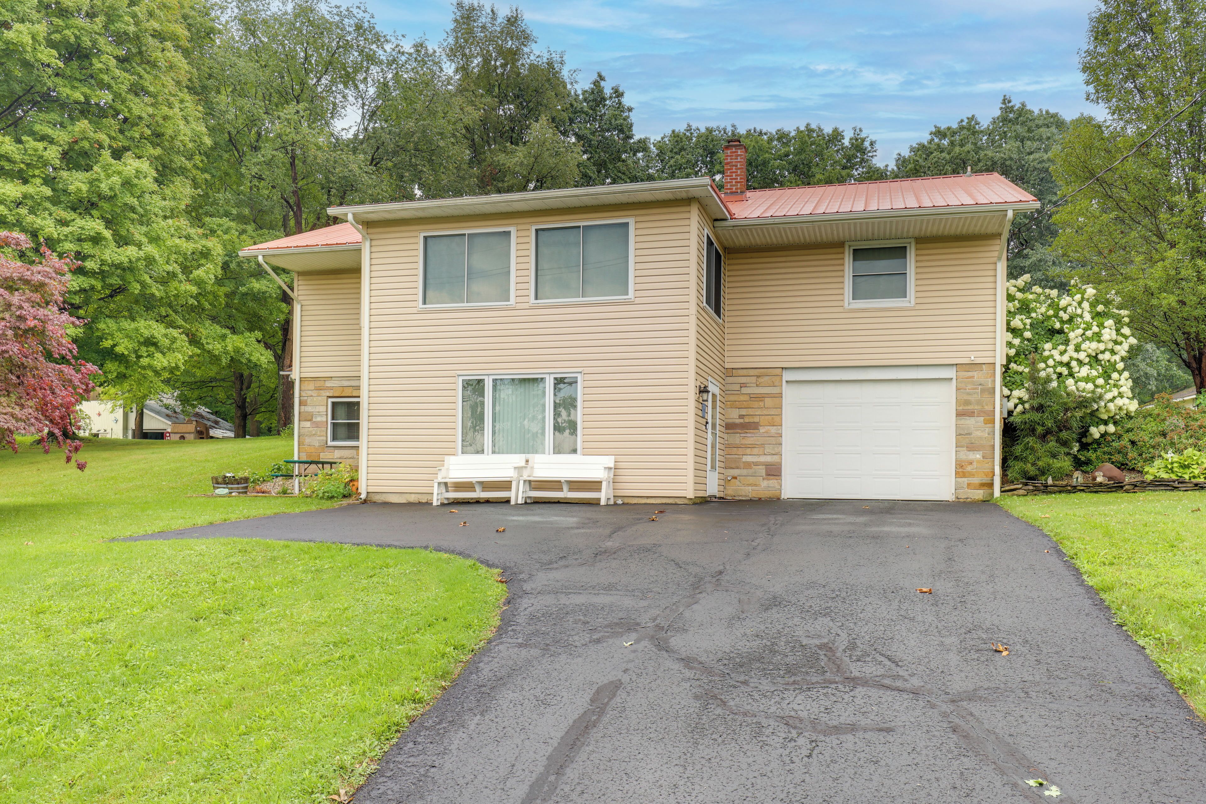 A two-story house with a garage, a front porch, and a well-maintained lawn.