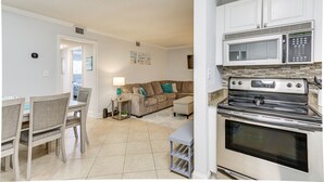 A kitchen with a microwave, oven, and stove. There is a dining area with a table and chairs. - Walk to Beach: Hilton Head Resort Condo w/ Pools! (Hilton Head Island)
