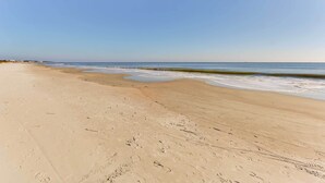 A wide sandy beach with gentle waves and a clear sky. - Walk to Beach: Hilton Head Resort Condo w/ Pools! (Hilton Head Island)