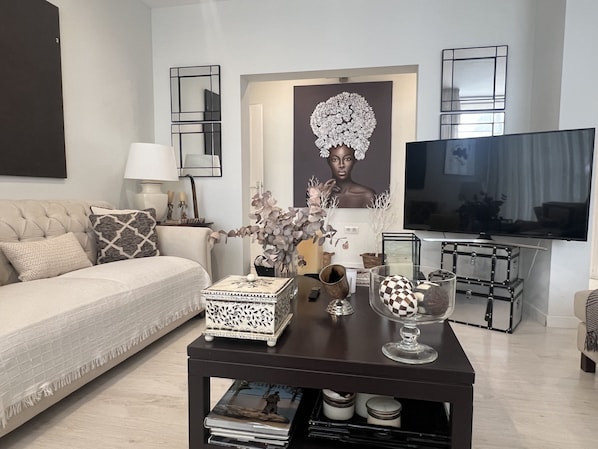A modern living room with a sofa, coffee table, and a TV.