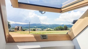 A room with a skylight, a view of a green landscape, and a small ventilation grate. - Amazing apartment in Spytkowice (Spytkowice)