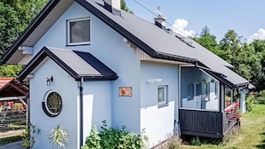 A two-story house with a dark roof, a small porch, and a visible number '352' on the side. - Amazing apartment in Spytkowice (Spytkowice)