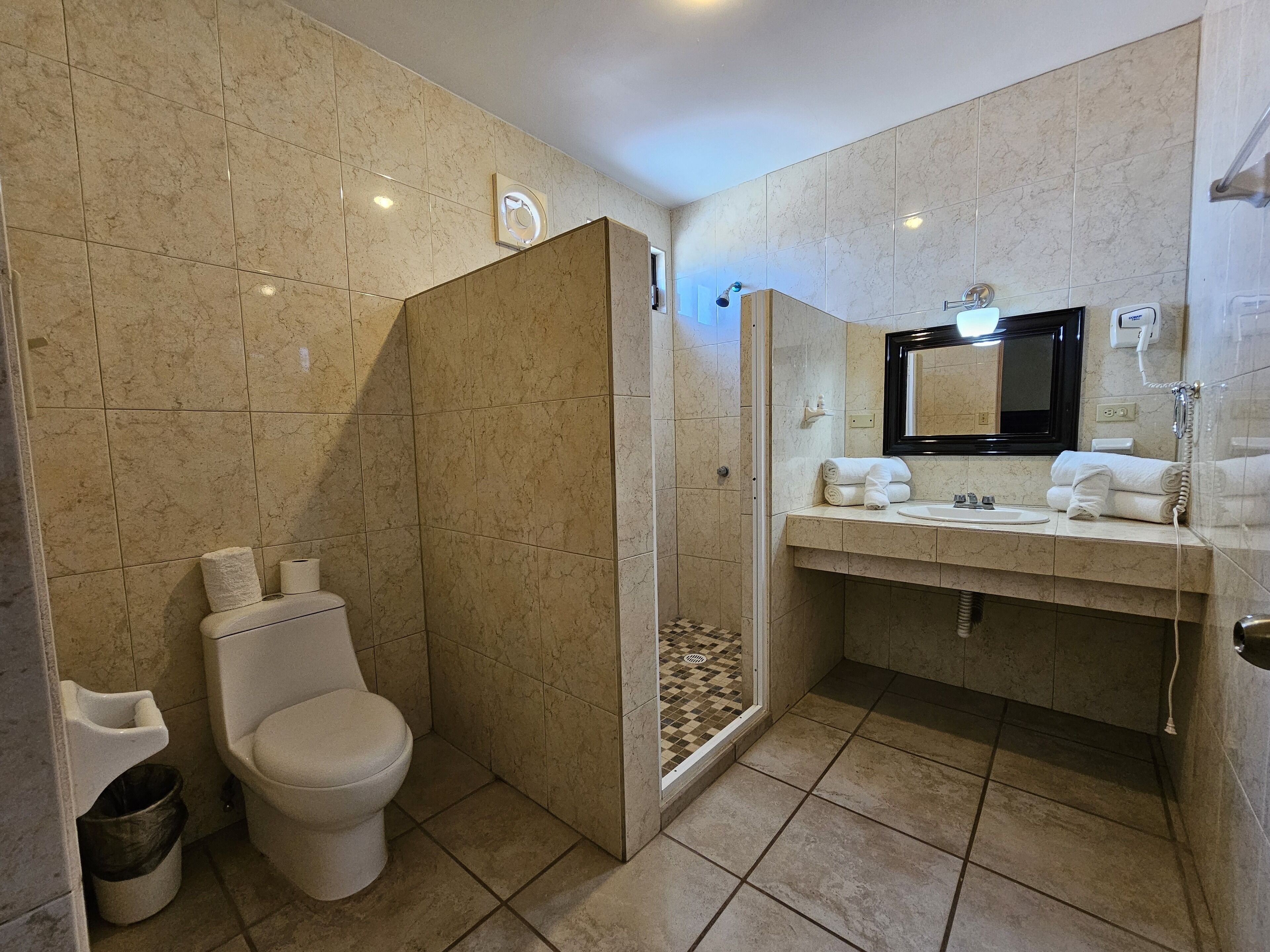 Un baño moderno con inodoro, ducha y lavamanos.