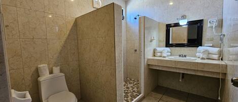 Un baño moderno con inodoro, ducha y lavamanos.