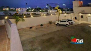 A night sky with stars visible from a balcony overlooking a parking area and buildings. - Hotel Oasis (Comondu)