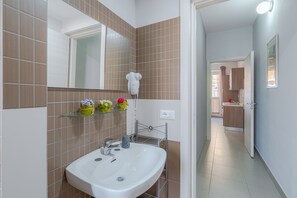 Ein Badezimmer mit Waschbecken, Spiegel und Handtuchhalter.