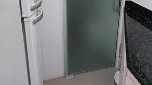 A room with a sliding door, a white cabinet, and a black countertop. - Você Ficará Hospedado a Menos de 5min a pé da Praia de Pitangueiras (Centro Guarujá)