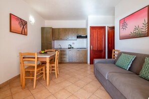 Un espace de vie compact comprenant un coin repas, une kitchenette et un canapé.
