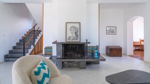 Un salon moderne avec une cheminée, un escalier et un coin salon confortable.