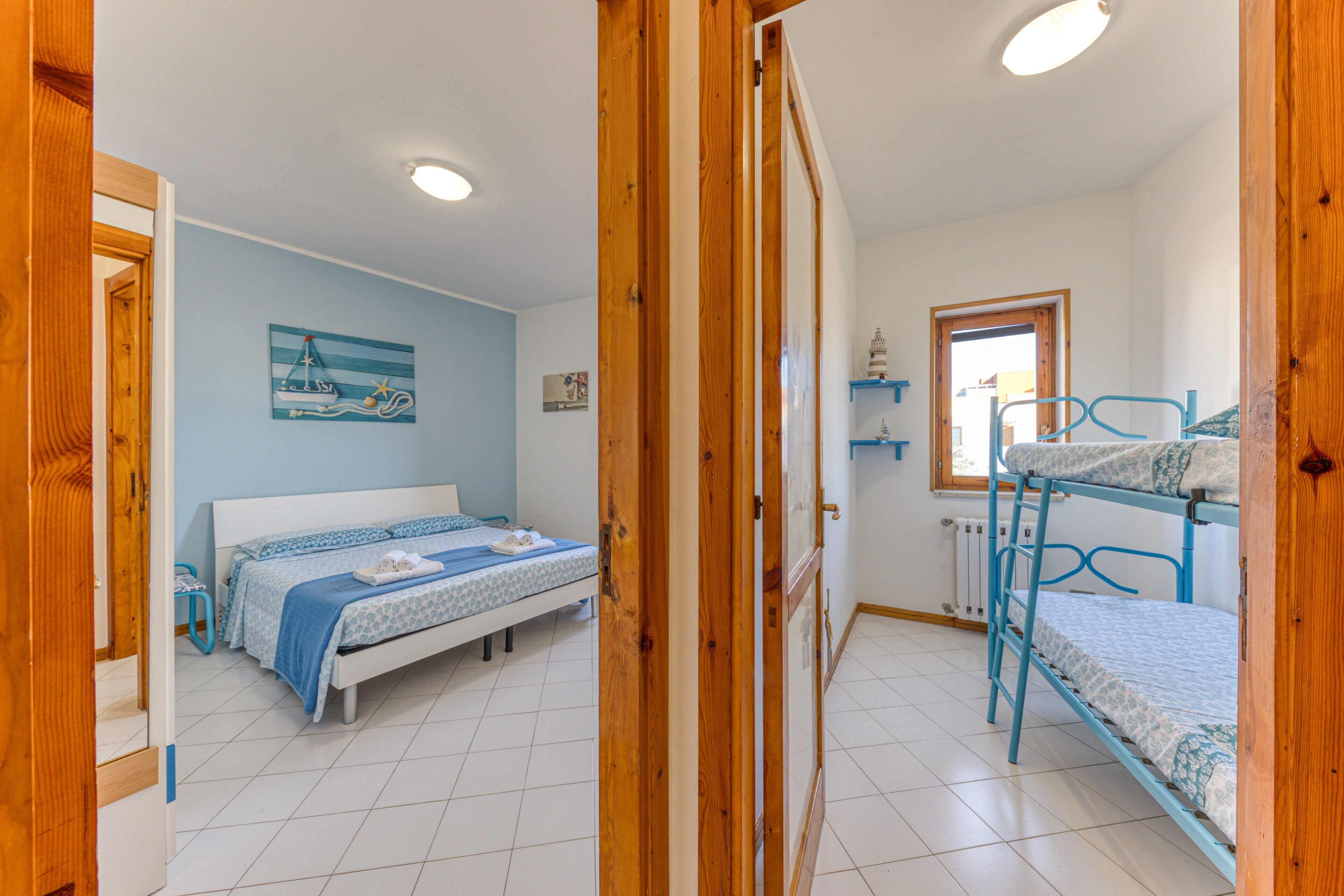Une chambre à coucher avec un lit, des lits superposés, une fenêtre et une porte.
