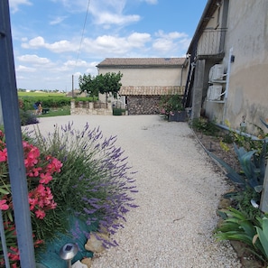 A gravel pathway leading to a building with a tiled roof and stone walls.