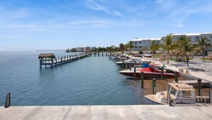 A marina with boats docked, a pier extending into the water, and a building with a white facade. - Best Catch on Grouper LN at Ocean Isles (Marathon)
