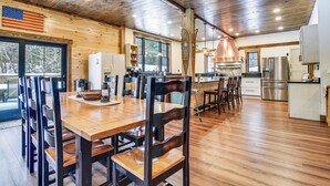 A spacious kitchen with wooden cabinets, stainless steel appliances, and a large window. - Maine Home w/ Hot Tub & Snowmobile Trail Access! (Township of Milton)