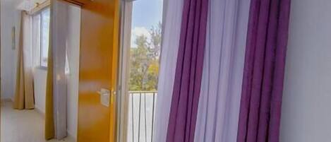 A corridor with a sliding door leading to a balcony.