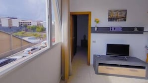Una sala de estar moderna con un amplio ventanal, chimenea y televisor de pantalla plana.