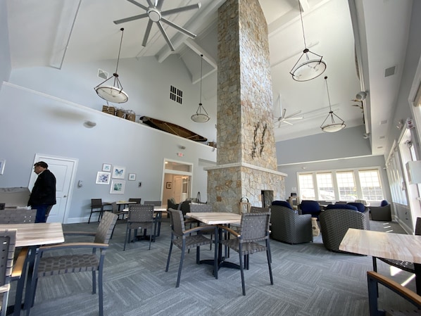 A spacious indoor area with high ceilings, stone pillars, and modern lighting fixtures.