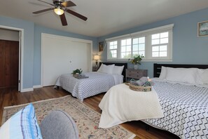 A bedroom with two beds, a ceiling fan, a window with blinds, and a nightstand with a lamp. - Perfect Home Near Disneyland (Anaheim)