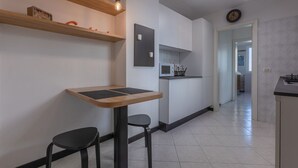 Eine moderne Küche mit einem Holztisch, zwei Stühlen und einem eingebauten Backofen.