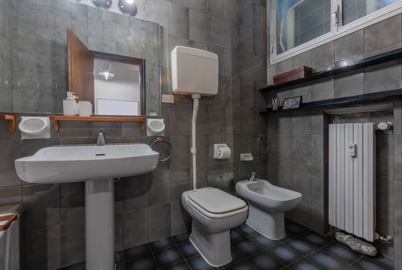 Un bagno con lavandino, WC, bidet e specchio.