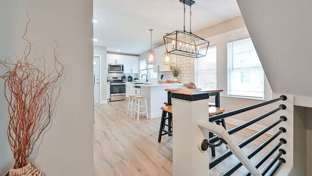 A modern kitchen with white cabinets, a central island, and pendant lighting.