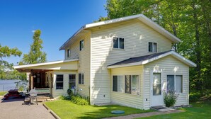 A two-story house with a covered porch, a small front yard, and a picnic table.