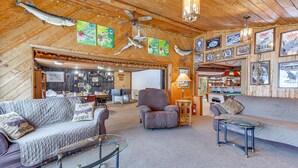 A cozy living room with a fireplace, comfortable seating, and a bar area.