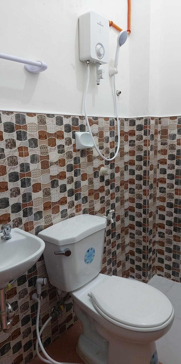 Un baño con inodoro, lavabo y cabina de ducha.