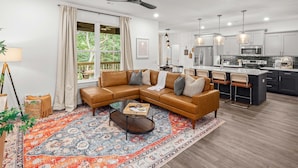 Un salon moderne avec un canapé d’angle, une table basse et un tapis à motifs.