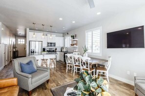 A modern kitchen with white cabinets, a central island, and pendant lighting.