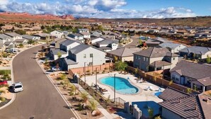 A residential area with houses, a curved road, and a swimming pool.