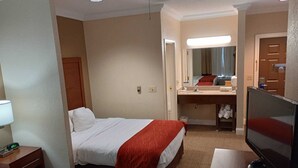 A hotel room with two beds, a TV, a desk, a mirror, and a bathroom visible through an open door. - SAMIR Stay at NW Expressway (Oklahoma City)