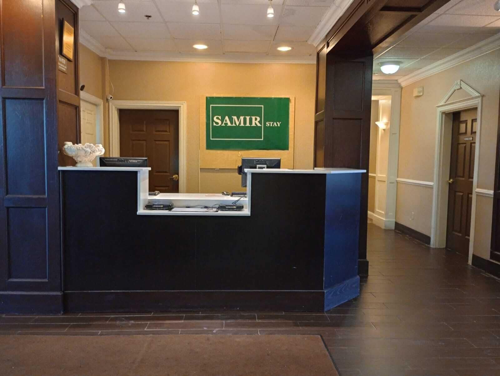 A reception desk with a sign that reads "SAMIR STAY".