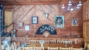 Ein Holzinterieur mit Essbereich, gerahmten Bildern und einer Kristallleuchtre.