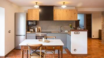 Een koelkast, een magnetron, een oven, kookgerei, borden en bestek