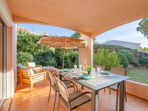 Enjoy al fresco dining under a shaded area surrounded by lush greenery and a clear view.