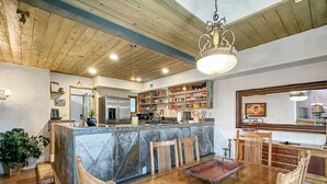 A kitchen with a central island, wooden dining table, and chairs. - Uptown Luxury Sedona House @ The Matterhorn Inn (Sedona)
