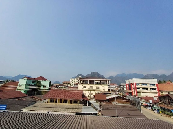 A town with buildings and mountains in the background. - Vang Vieng Charming Boutique Hotel (Vang Vieng)