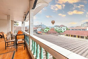 Ein Balkon mit Blick auf eine Stadtlandschaft und zwei Heißluftballons.