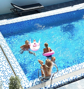 A swimming pool with a tiled edge and a diving board. - Vang Vieng Charming Boutique Hotel (Vang Vieng)