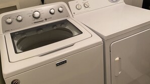 Eine Maytag Waschmaschine und Trockner Kombination mit mehreren Bedienelementen und einer Glasfront.