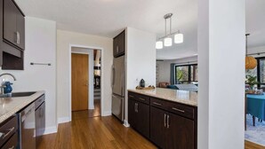 A modern kitchen with dark wood cabinets, stainless steel appliances, and a light wood floor. - Kate's Kayak Cove on Lake Keowee! (Seneca)