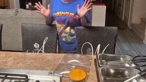 A person standing in a kitchen with a gas stove, a jar labeled 'Flour', and a sink with utensils. - B&B at the Paseo's by Wanda (El Paso)