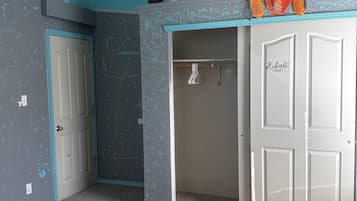 A bedroom with a bed, a wardrobe, and a door.