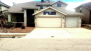 A residential house with a garage, satellite dish, and a signboard. - B&B at the Paseo's by Wanda (El Paso)