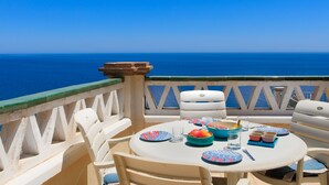 Une table dressée pour le dîner, avec vue sur la mer.