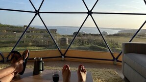 Uitzicht vanuit een kamer in een geometrisch koepel, met een tafel, een mok en een glas drinken.